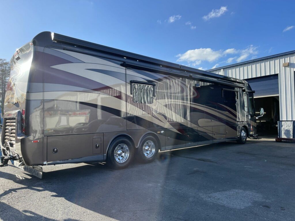 large silver rv with black and white stripe elements from the right side