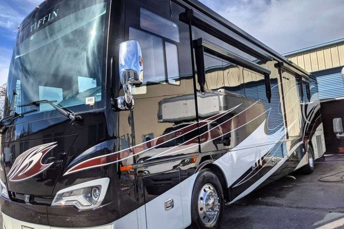 large black rv with red and white painted elements